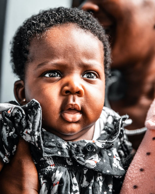 Cross Stitch | Abidjan - Baby Girl Wearing Black Floral Dress - Cross Stitched