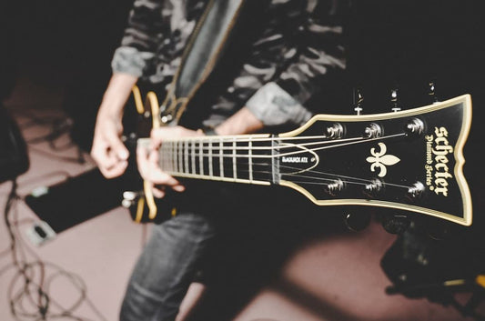 Cross Stitch | Bass - Person Playing Electric Guitar In Black And White Long Sleeve Shirt - Cross Stitched