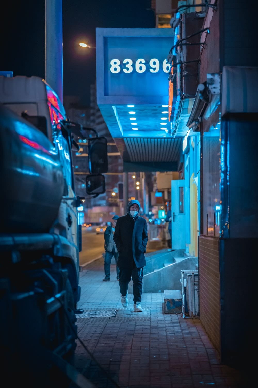 Cross Stitch | Dalian - Man In Black Jacket Walking On Sidewalk During Night Time - Cross Stitched