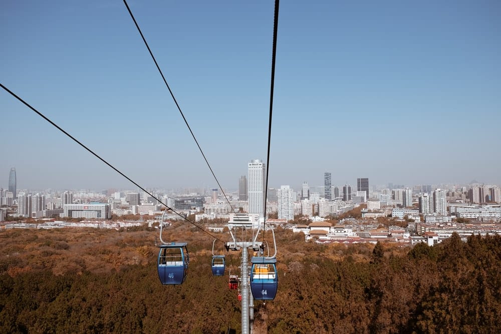 Cross Stitch | Jinan - Cable Cars Over City Buildings During Daytime - Cross Stitched