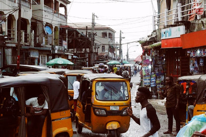 Cross Stitch | Lagos - People On Street And Different Vehicles Near Buildings During Daytime - Cross Stitched