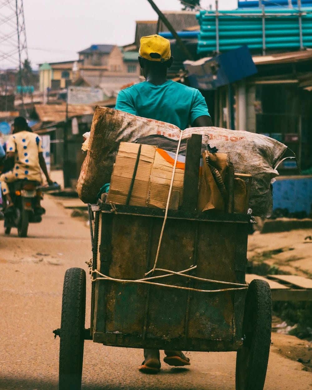 Cross Stitch | Lagos - Person Pulling Brown Wooden Cart - Cross Stitched