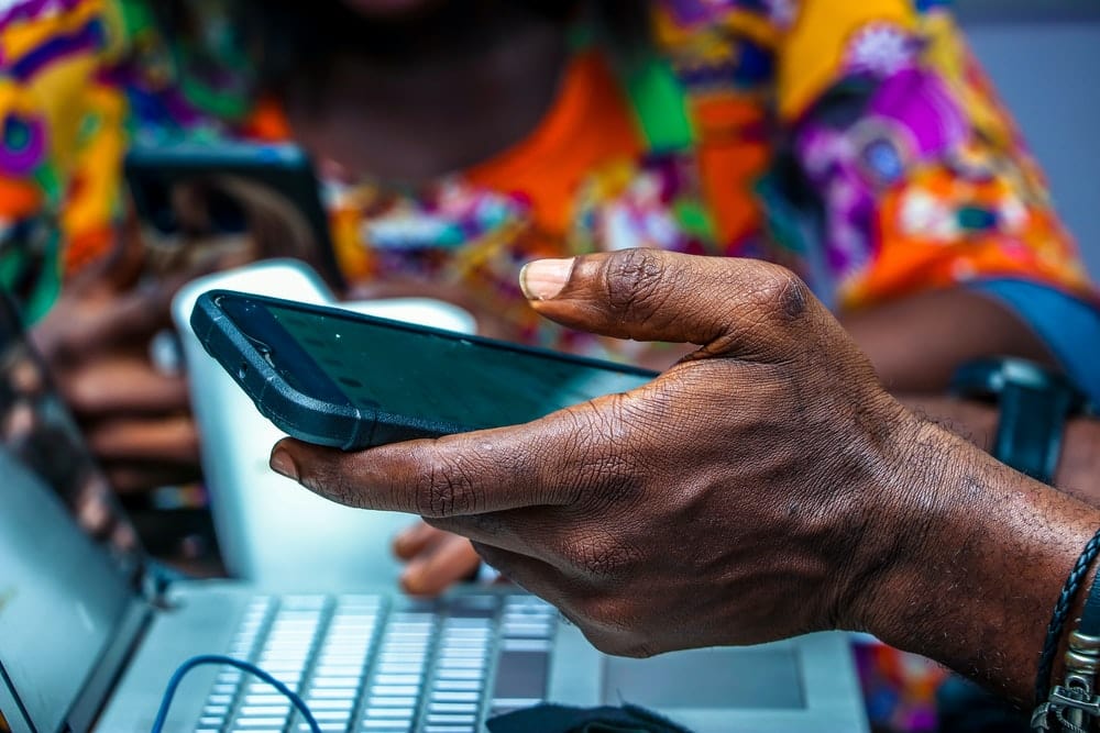 Cross Stitch | Lagos - Shallow Focus Photo Of Person Holding Black Android Smartphone - Cross Stitched