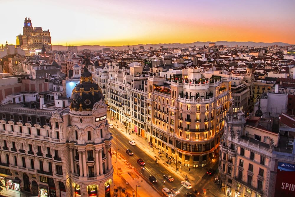 Cross Stitch | Madrid - Aerial Photography Of Vehicles Passing Between High Rise Buildings - Cross Stitched