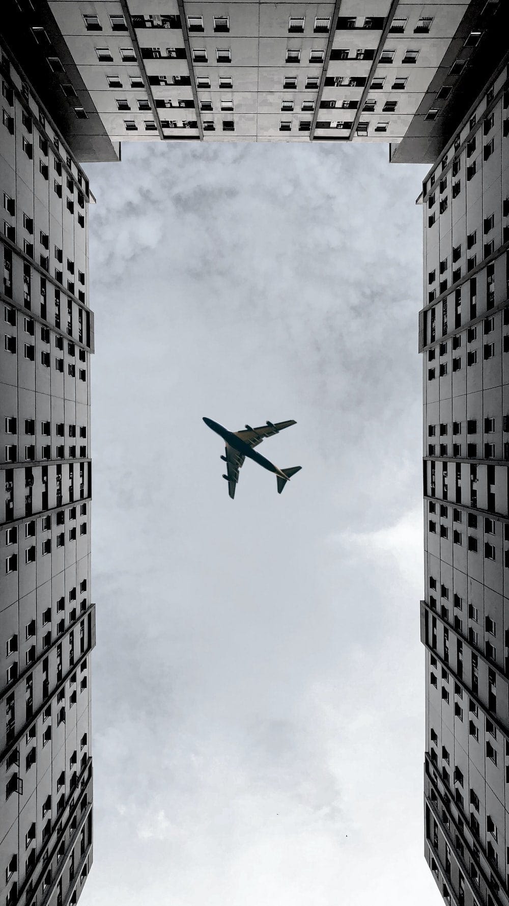 Cross Stitch | Surabaya - Airplane Flying Over The Building During Daytime - Cross Stitched