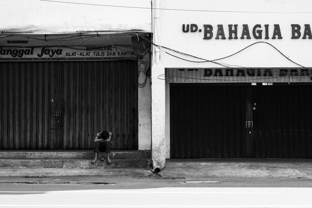 Cross Stitch | Surabaya - Grayscale Photo Of Person Sitting Building Stair - Cross Stitched