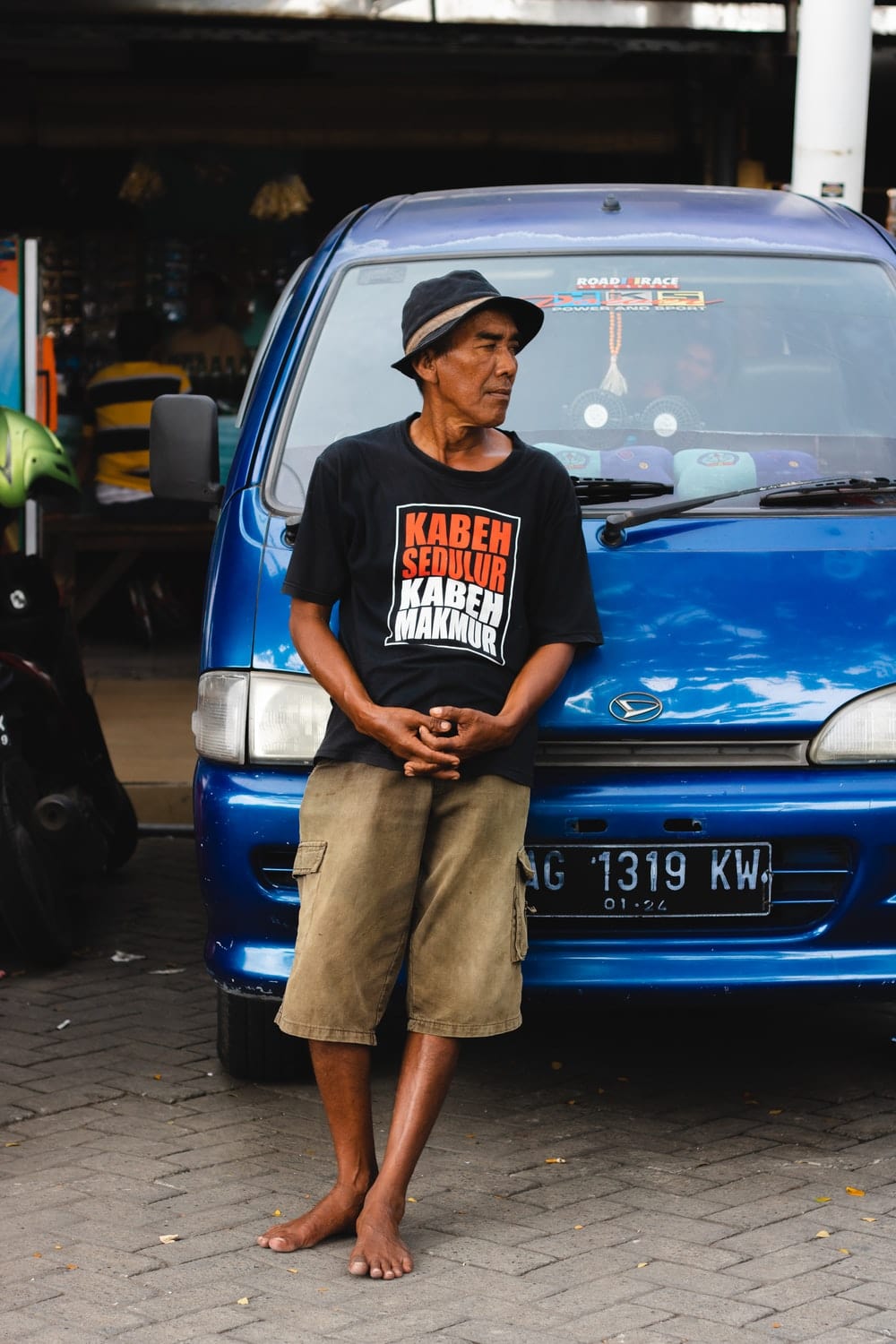 Cross Stitch | Surabaya - Man Leaning On Blue Vehicle During Daytime - Cross Stitched